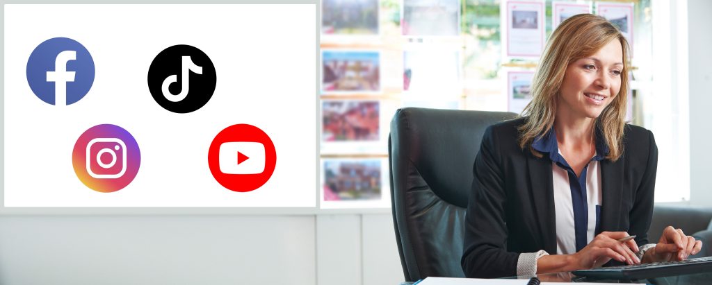An image of a female real estate agent at desk doing social media marketing at computer. 